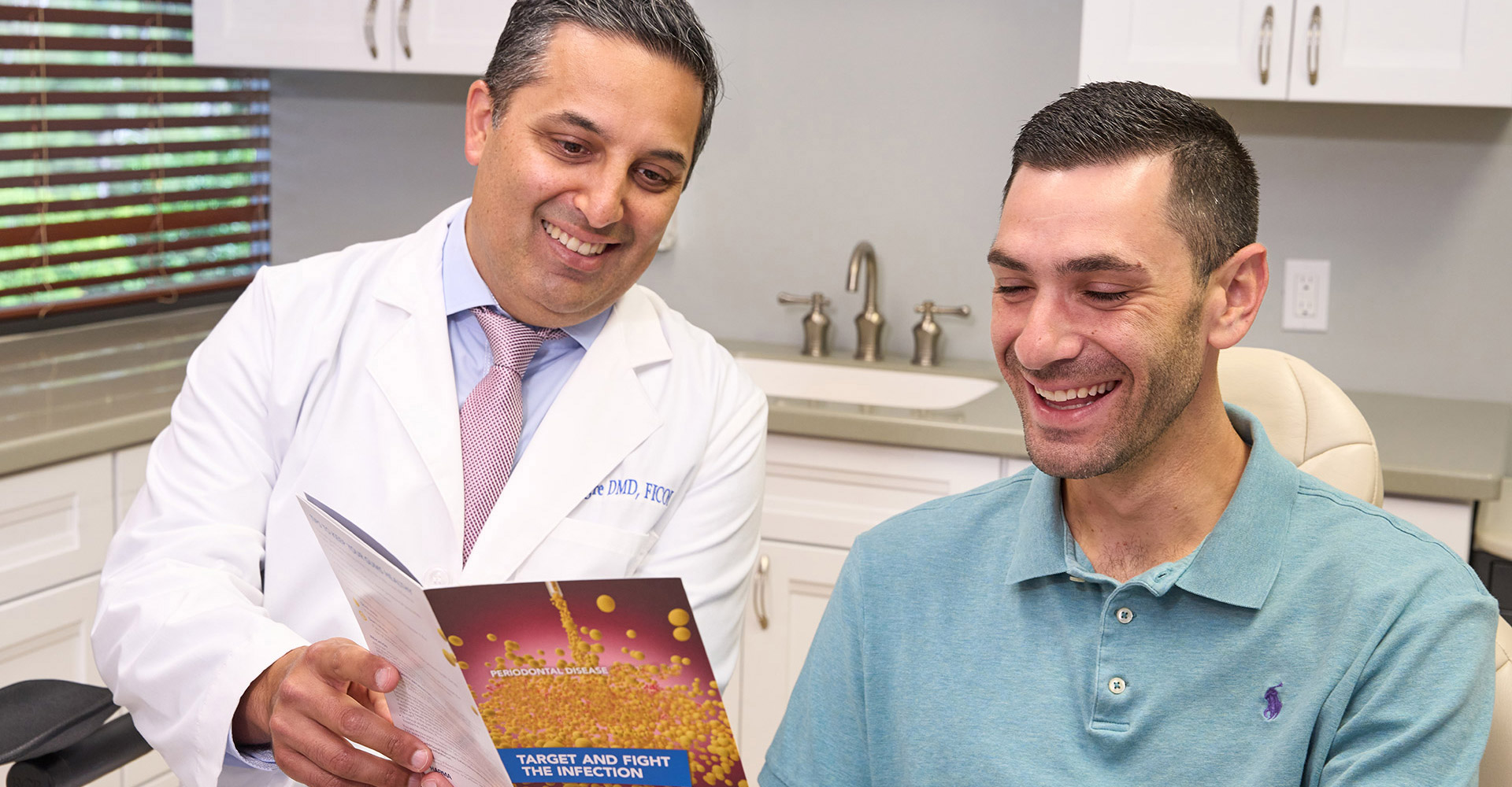 Dr. Alegre showing a patient a brochure about Gum Disease Treatment.