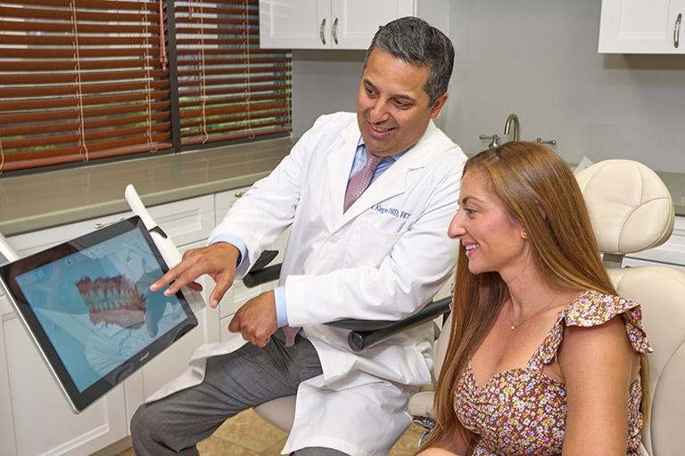 Dr. Alegre showing a patient their digital smile design.